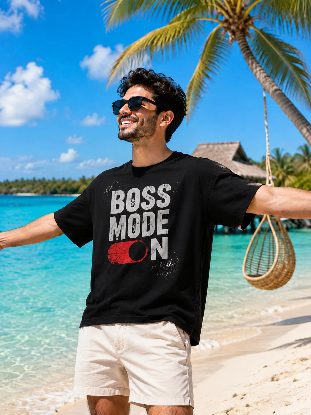 Black oversized T-shirt with "Boss Mode On" typographic print and toggle-switch graphic, front view on male model against a colorful architectural backdrop